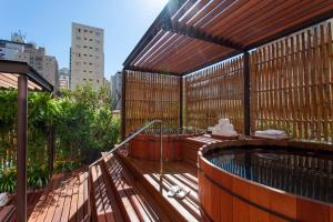 een hot tub op het terras van een gebouw bij Hotel Emiliano in Sao Paulo