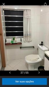 uma casa de banho com um WC branco e uma janela em Bella Ciao Hostel no Rio de Janeiro