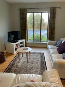 a living room with a couch and a coffee table at Letterfrack Farm Lodge house in Letterfrack village Connemara in Letterfrack