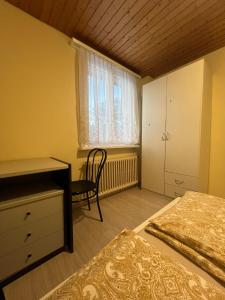 a bedroom with two beds and a desk and a window at Niederdorf, Baselland Hotel in Niederdorf