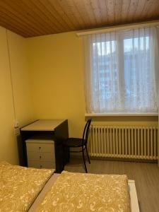um quarto com 2 camas, uma secretária e uma janela em Niederdorf, Baselland Hotel em Niederdorf