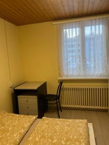 1 dormitorio con 2 camas, escritorio y ventana en Niederdorf, Baselland Hotel en Niederdorf