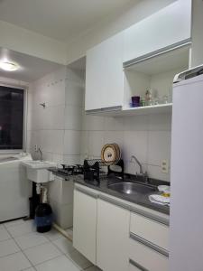 a white kitchen with a sink and a counter at SUA ESTADIA PERFEITA in São Luís
