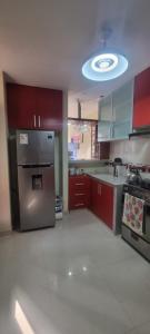 een keuken met rode kasten en een roestvrijstalen koelkast bij Casa / Departamento en Chiclayo in Chiclayo