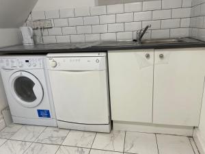 eine Küche mit einer Waschmaschine und einem Waschbecken in der Unterkunft Double bedroom with bathroom en suite in London Docklands Canary Wharf E14 in London