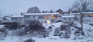 uma casa na neve com um quintal coberto de neve em Hus ved Lillestrøm by em Lillestrom