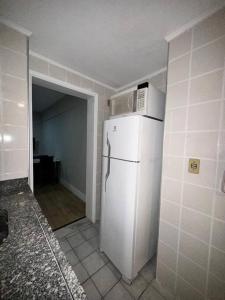 een keuken met een witte koelkast en een magnetron. bij Amplo Apartamento no Cambuí II in Campinas
