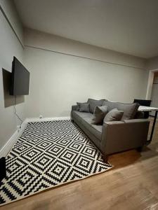 een woonkamer met een bank en een tapijt bij Amplo Apartamento no Cambuí II in Campinas