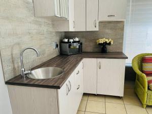 cocina con fregadero y microondas en Private room in Rustenburg, en Rustenburg