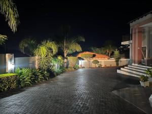 a cobblestone walkway in front of a building at night at Private room in Rustenburg in Rustenburg