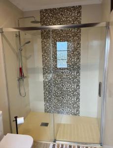 een douche met een glazen deur in een badkamer bij La Casa del Marinero in Cudillero +17 foto's