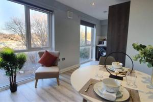 a living room with a table and chairs and windows at Inviting 1-Bed Apartment in the heart of Sheffield in Sheffield