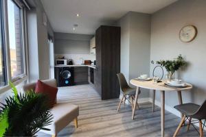 een woonkamer met een tafel en stoelen en een keuken bij Inviting 1-Bed Apartment in the heart of Sheffield in Sheffield