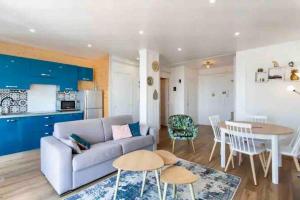 ein Wohnzimmer mit einem Sofa und einem Tisch in der Unterkunft Nice 2P Vue Mer- 5min plage, Terrasse, AC, Parking in Nizza