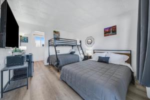 een slaapkamer met een bed en een bureau met een televisie bij Canyon's Edge Route 66 Motel in Ash Fork