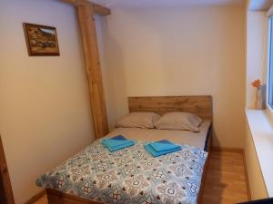 a small bedroom with a bed with two blue folders at Pakrantė in Klaipėda