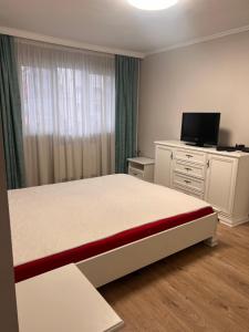 sypialnia z łóżkiem i komodą z telewizorem w obiekcie Nymfa Residence w mieście Oradea