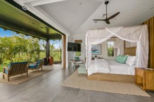 - une chambre avec un lit à baldaquin dans l'établissement Kukui'ula Luxury Vacation Home 62- Alekona Kauai, à Koloa