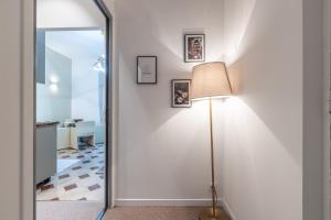 une lampe au sol à côté d'un mur blanc avec un miroir dans l'établissement Menton Casino, à Menton 46 autres photos