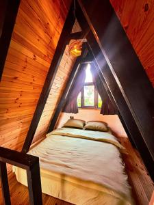 a bed in a wooden room with a window at Joy Sapanca in Sapanca