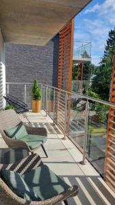 a balcony with two chairs and a railing at Apartament Green Park, Polanica Residence garaż podziemny w cenie & mini SPA & Rowery in Polanica-Zdrój