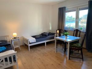a room with two beds and a table and a window at Top Monteurwohnung Riede mit super Anbindung in Riede
