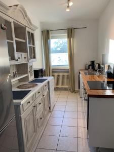 a kitchen with white cabinets and a large window at Top Monteurwohnung Riede mit super Anbindung in Riede +8 photos