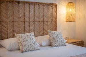 a bedroom with a bed with two pillows on it at Anais Of Naxos in Agia Anna Naxos