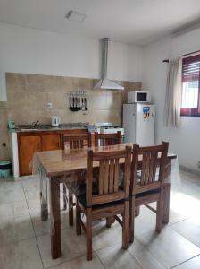 - une cuisine avec une table et des chaises en bois dans l'établissement Departamento Costanera Alta Gracia, à Alta Gracia