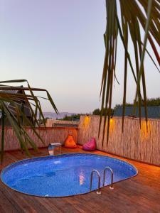 a blue swimming pool on a wooden deck with a palm tree at Joy Sapanca in Sapanca