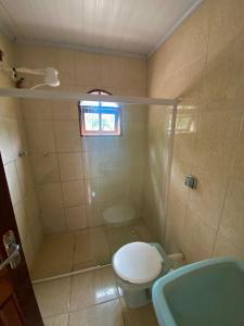 uma casa de banho com um chuveiro, um WC e um lavatório. em Marcelo Chale em Paraty