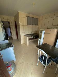a small kitchen with a table and a refrigerator at Marcelo Chale in Paraty