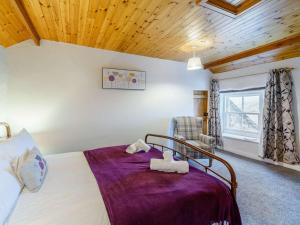 a bedroom with a bed and a chair in a room at 4 Bed in Keswick 86250 in Threlkeld