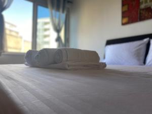 uma pilha de toalhas sentadas em cima de uma cama em Nicole Apartments Rental em Durrës