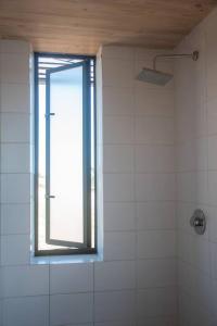 baño con ventana y ducha de azulejos blancos en Casa Loft Vista Increíble incluye jacuzzi en Matanzas