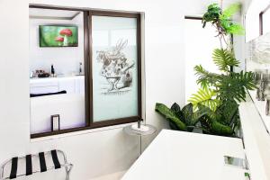 a bathroom with a window and plants in it at Wilderness Waters Boutique Suites - Adults Only in Wilderness