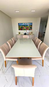 une salle à manger avec une table et des chaises blanches dans l'établissement Boa Viagem Piedade Beach, à Récife