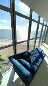 - un grand canapé bleu dans une chambre avec vue sur la plage dans l'établissement Boa Viagem Piedade Beach, à Récife