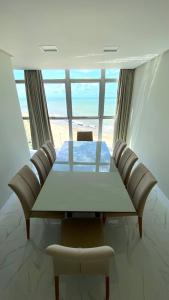 - une table et des chaises dans une chambre avec vue sur la plage dans l'établissement Boa Viagem Piedade Beach, à Récife