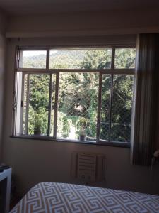 - une chambre avec une grande fenêtre ornée de plantes dans l'établissement Apartamento aconchegante, à Rio de Janeiro