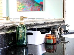 a bottle of wine sitting on a sink in a bathroom at Artful Retreat: Modern Mansion in Surrey