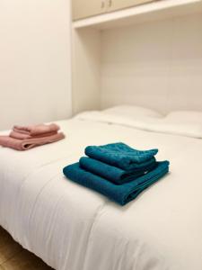 two blue towels sitting on top of a white bed at Pavia in Charme - Intero Appartamento in Pavia