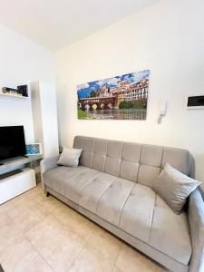 un soggiorno con divano e un dipinto sul muro di Pavia in Charme - Intero Appartamento a Pavia