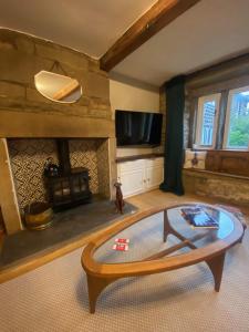 a living room with a coffee table and a fireplace at The Weavers Cottage in Oxenhope