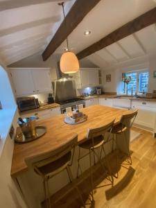 a kitchen with a wooden counter top and a table at The Weavers Cottage in Oxenhope