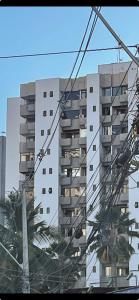 a tall white apartment building with a lot of power lines at Flat com Ar Condicionado Ana Regis AP 307, Salvador in Salvador