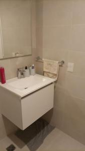 a white bathroom with a sink and a mirror at Hermoso departamento a estrenar, Calido y Unico in Buenos Aires