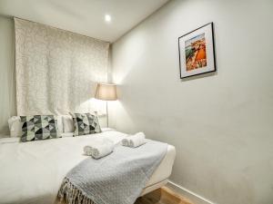 een slaapkamer met een bed met handdoeken erop bij Luxe Apartment by Hello Homes Sitges in Sitges