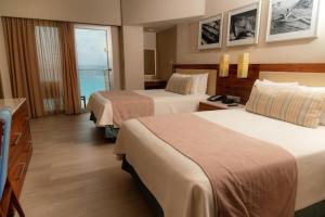 a hotel room with two beds and a balcony at Emporio Cancun - Buy All Inclusive Option in Cancún