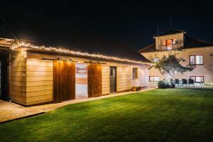 a wooden building with lights on the side of it at KAPINA sk - Dom Jasna in Liptovský Mikuláš
